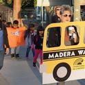 UC CalFresh manager Karina Macias, left, leads the Virginia Lee students along with teachers Carolyn Lozano and Aubrey Rutherford (left to right, holding the school bus banner.)