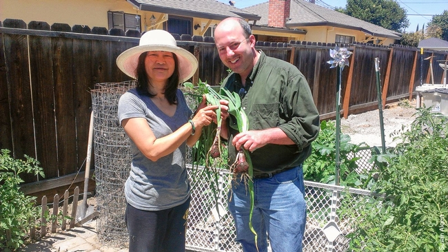 Rob Bennaton, right, urban agriculture advisor for the Bay Area, shows off freshly picked onions.