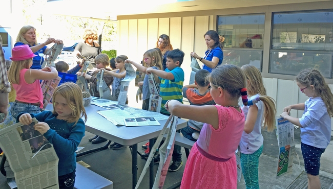 UCCE gardenen coordinator Kim Stempien (left in blue shirt) presenting a worm compost lesson. Also pictured are two RISE students (in the back), afterschool students, and UCCE nutrition educator Margarita Alvord (right in blue shirt).