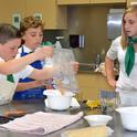Elisabeth Watkins, right, winner of the 2019 4-H Youth in Action Award for Healthy Living, mentoring younger 4-H members on a cooking project.
