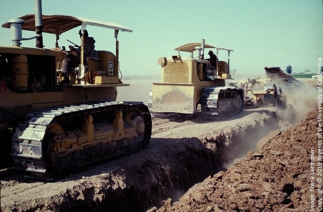 Figure 8. Tandem D8H crawlers pulling a large slip plow to thoroughly mix a stratified soil near Santa Maria. The result has been described as a 