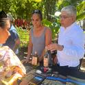 Paulina Rojas, PhD Student in the UC Davis Ecology Graduate Group and research project leader Samuel Sandoval Solis, UC Cooperative Extension specialist in water resources management offering pulque tastings to an event attendee