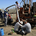 UC Davis researchers insert a device that continuously collects water samples underground, providing real-time data on nitrate contaminant movement. Photo by Isaya Kisekka