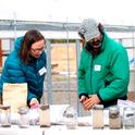 Katharina Ullmann, Organic Agriculture Institute training and technical assistance coordinator, left, and Andrew Brait, field day panelist from Full Belly Farm, view results of soil health test.