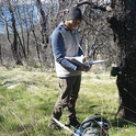 Kendall Calhoun checks a motion-sensor camera trap at Hopland. The team visits each of the 36 cameras in the wildlife detection grid once every three months to download new photos, replace broken parts, and clear grass and other debris that may block the view of animals. Photo by Marissa Ortega-Welch