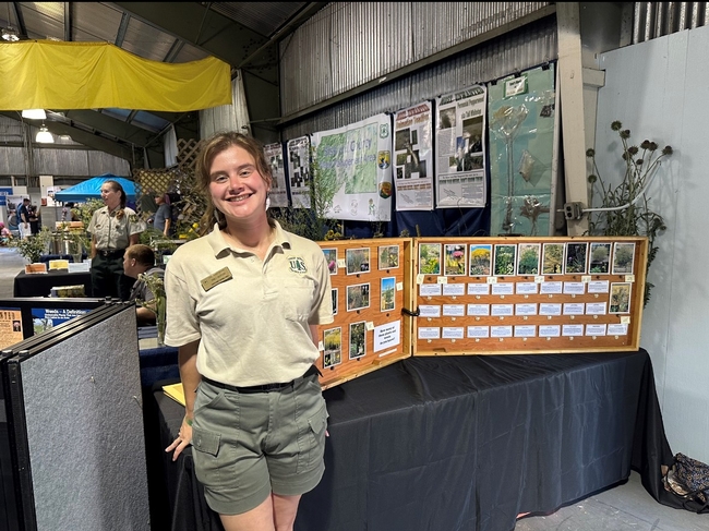 Emily Jackson stands by a booth about invasive plants at the Siskiyou County Fair