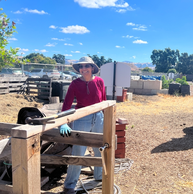 A volunteer repairs the railing