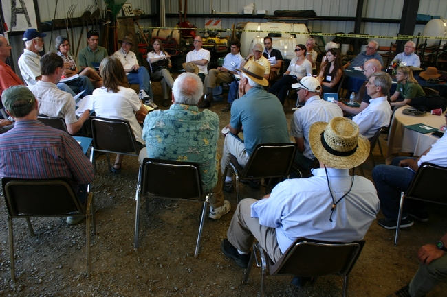 Researchers, farmers, and agricultural professionals learn from one another in discussion at a recent field day.