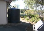 A foothill dwelling landscaped with a five-foot non-combustible zone. The building is also equipped with an extra large rain barrell that collects water during storms for irrigating plants.
