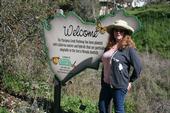 UC ANR Master Gardener coordinator Kris Randal with the welcome sign on the Mariposa Creek Parkway.