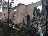 Steve Quarles and Yana Valachovic examined houses in Paradise after the devastating 2018 Camp Fire. Quarles holds up a vent screen that may have allowed embers to enter the house. Photo by Yana Valachovic