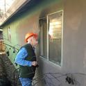 Steve Quarles, UC Cooperative Extension advisor emeritus, looks at a garage attached to an older house in Paradise where the radiant heat from a nearby fence and line of planted vegetation ignited and were sufficiently hot enough to break the single pane glass. Photo by Yana Valachovic