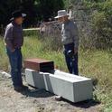 UC Cooperative Extension rangeland farm advisor Royce Larsen, left, discusses the ground-level water trough with inventor George Work.