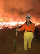 Katie Low standing in front of a prescribed fire