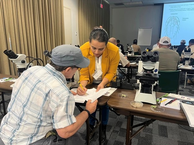 Sandipa Gautam showing a student the keys to predatory mites