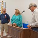 Kearney director Jeff Dahlberg, right, presented letters, a certificate and medallion to the retiring advisor. In the center is Pete's longtime colleague Cherie McDougald.