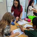 Teen leader Siyan guides youth at the Boys and Girls Club through an activity of sorting buttons.