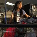 Isabella Kap, 8, helps her grandmother at the laundromat in Long Beach, where members of the large Cambodian community often lend money to one another through informal groups rather than use banks. (Carolyn Cole / Los Angeles Times)