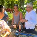 Paulina Rojas, PhD student in the UC Davis Ecology Graduate Group and research project leader Samuel Sandoval Solis, UC Cooperative Expension specialist in water resources managment offering pulque tasting to an event attendee.