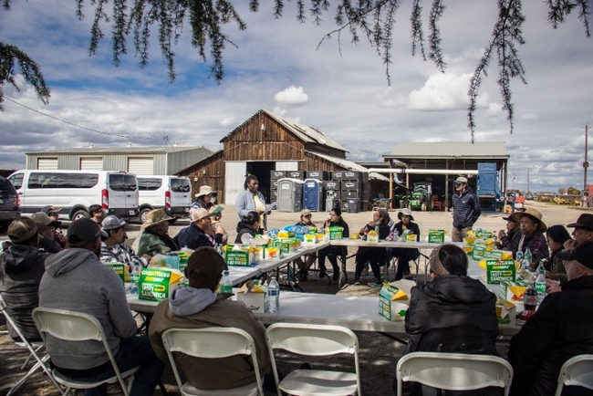 People sit outside at a circle of tables