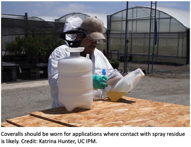 Applicator wearing coveralls while handling pesticides.