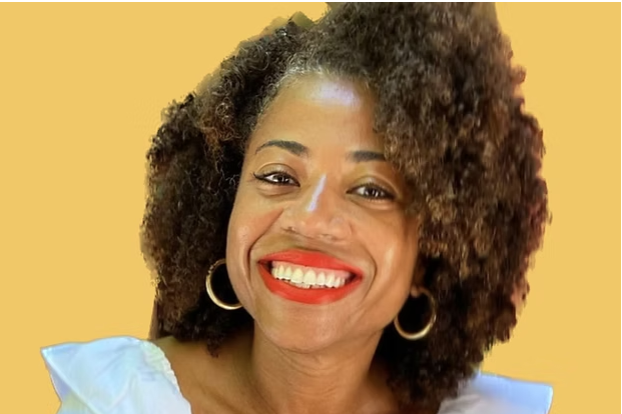 Picture of a Shana Minei Spence, a black woman with a big smile and gold hoop earings