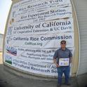 Aaron Alvarez, UC Davis graduate student, accepts D. Marlin Brandon Rice Research Fellowship award during the California Rice Field Day 2021.