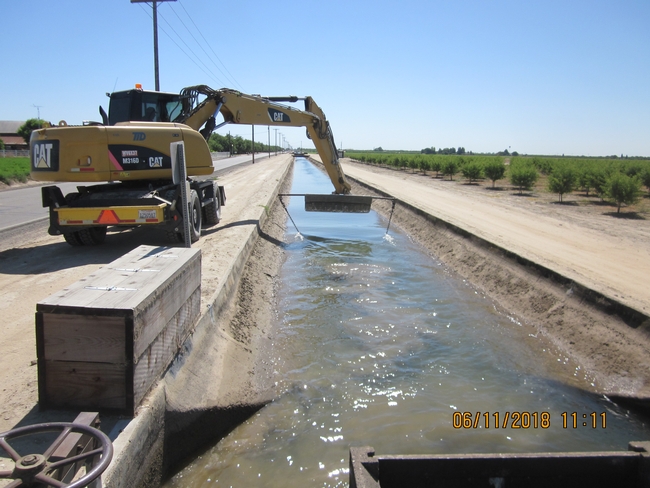 Removing seeds from irrigation canal near Tulare, CA using chaining