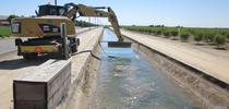 Removing seeds from irrigation canal near Tulare, CA using chaining for UC Weed Science Blog