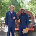 UCCE farm advisor Dr. Franz Niederholzer and UCCE specialist Dr. Peter Larbi pose behind an airblast sprayer in Arbuckle, CA