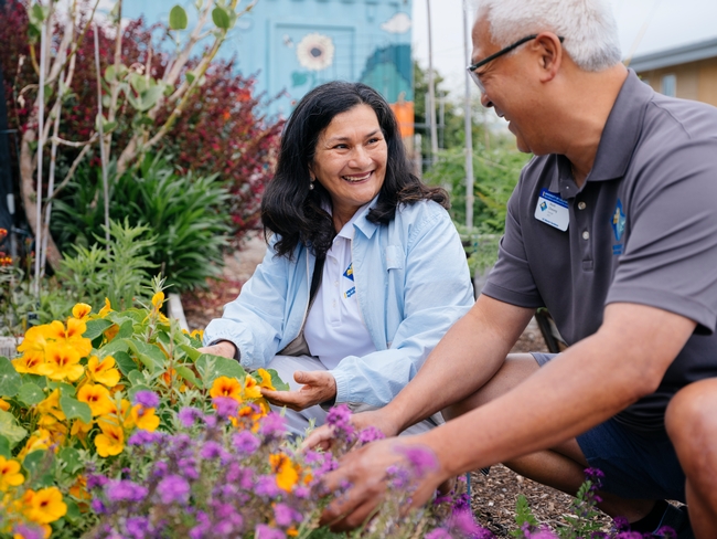 Two people gardening in a community green space