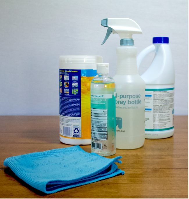 Several plastic bottles of cleaning solutions and a blue microfiber towel.