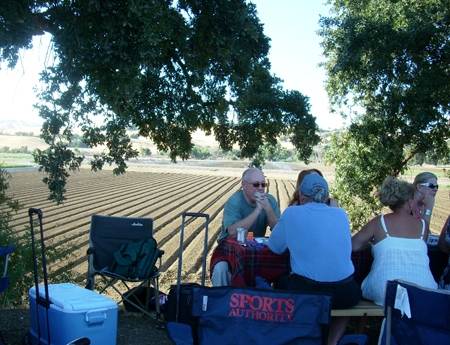 people enjoying picnic by farm field
