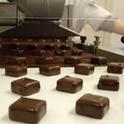 Una docena de dulces bañados en chocolate salen de la línea de producción