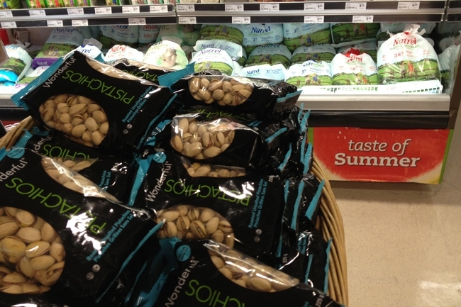 Una tienda de abarrotes canadiense vende pistachos de California (al frente) y leche en bolsas (atrás).