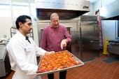 El chef Bob Walden (derecha) y Arnulfo Herrera, cocinero, muestran los tomates asados en la Universidad de California en Davis. (Foto por: Gregory Urquiaga/UC Davis)