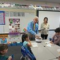 El congresista de EUA Jim Costa mezcla la ensalada para los estudiantes de la primaria La Vina en el condado de Madera County. La educadora de nutrición de UCCE, Angélica Pérez junto al congresista.
