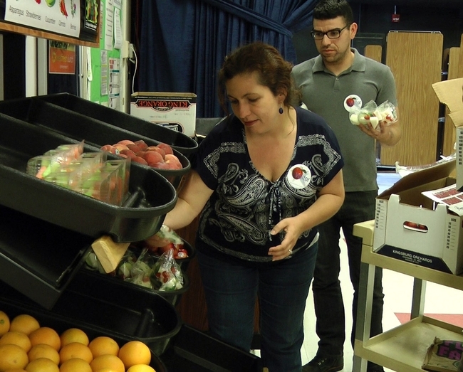 Terri Spezzano loads fresh fruit and vegetables in an afterschool 'farmers market' in Turlock.