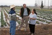 Michael Yang, left, and Richard Molinar talk to a Southeast Asian farmer.