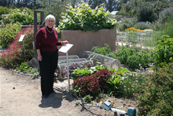 Rose Hayden-Smith in front of a demonstration Victory Garden.