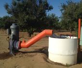 Groundwater is drawn by a pump to irrigate almonds in Fresno County.