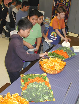 Children at a UCCE event enjoying fresh fruit and vegetables.
