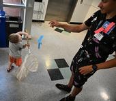 Braden Nguyen, 3, of Davis, stretches to net a paper butterfly tossed by UC Davis doctoral student Christofer Brothers at the Bohart Museum of Entomology open house. (Photo by Kathy Keatley Garvey)