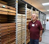 Jeff Smith, curator of the Lepidoptera collection at the Bohart Museum, stands by the drawers he crafted. (Photo by Kathy Keatley Garvey)