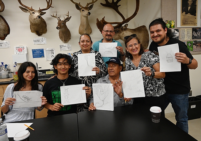 Following Professor Miguel Angel Miranda's workshops, participants were invited to pose for a photo with their sketches. (Photo by Kathy Keatley Garvey)