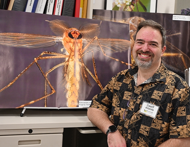 UC Davis medical entomologist-geneticist Geoffrey Attardo is pictured next to one of his mosquito images. (Photo by Kathy Keatley Garvey)