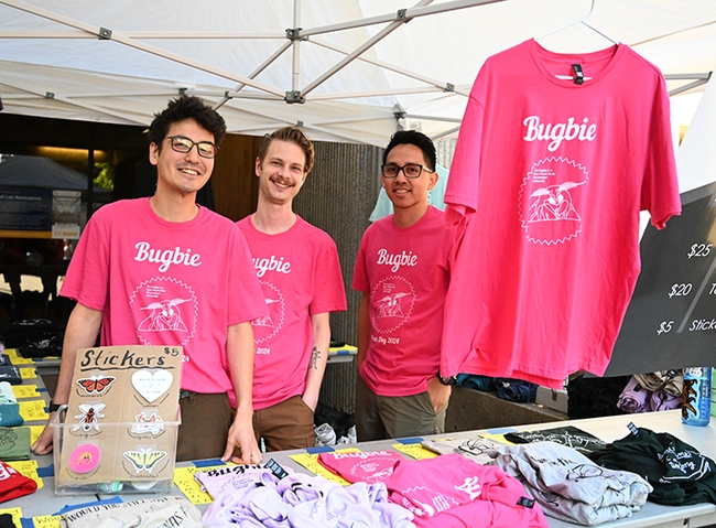 In the pink! Staffing the Entomology Graduate Student Association booth are (from left) Marshall Nakatani, Curtis Carlson and Richard Martinez. The T-shirts were among the top three best sellers of the day. (Photo by Kathy Keatley Garvey)