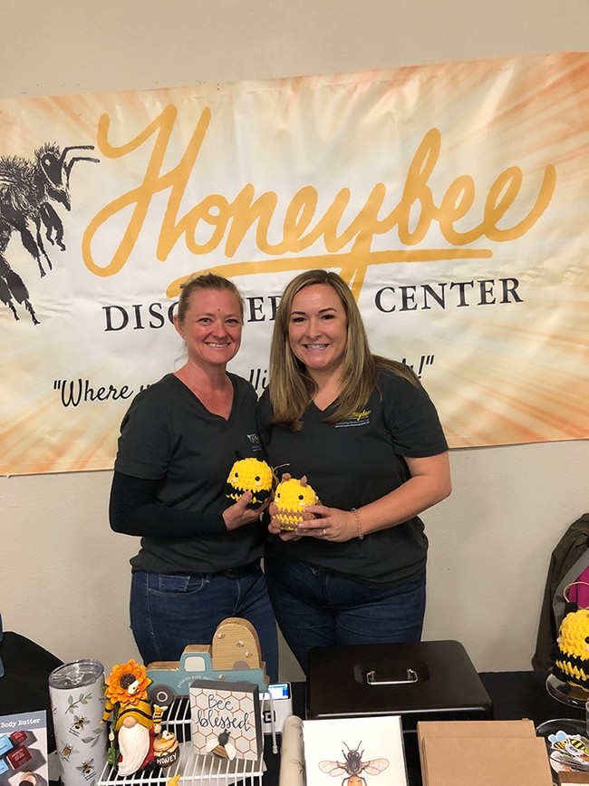 Alexis Herbert and Missy Rianda of the Honeybee Discovery Center, Orland, offering bee products. (Photo by Kathy Keatley Garvey)