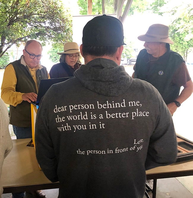 This man waiting in line at a California Honey Festival booth wears a sweatshirt expressing a message of compassion, unity and love. (Photo by Kathy Keatley Garvey)