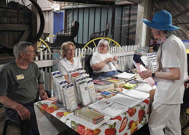 Marilyn Sexton of Fairfield, who plants tomatoes every year, asks a question at the UC Master Gardeners table at the Dixon May Fair. Master Gardeners (from left) are Tom Hutson, Julie Smith, and Betty Buxton. (Photo by Kathy Keatley Garvey)